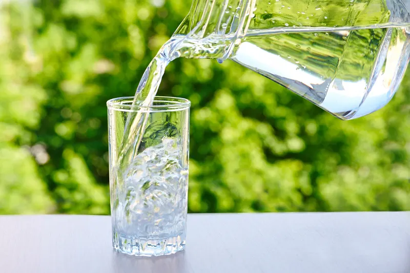 Water being poured from a jug into a glass - 10 Simple Sunburn Hacks to Soothe Your Skin