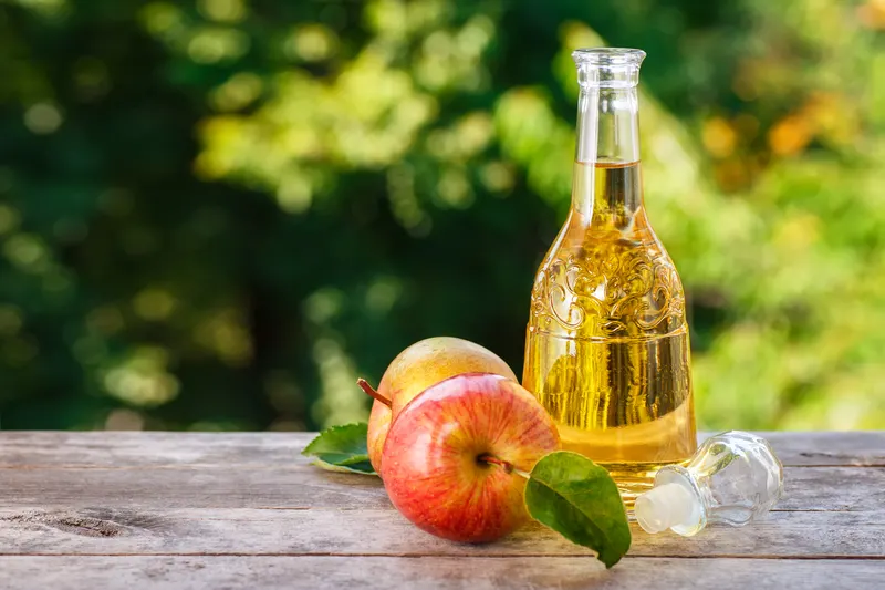Bottle of apple cider vinegar with apples - 10 Simple Sunburn Hacks to Soothe Your Skin